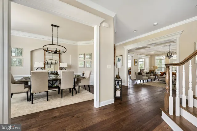 a view of a a dining room and livingroom with furniture wooden floor a chandelier