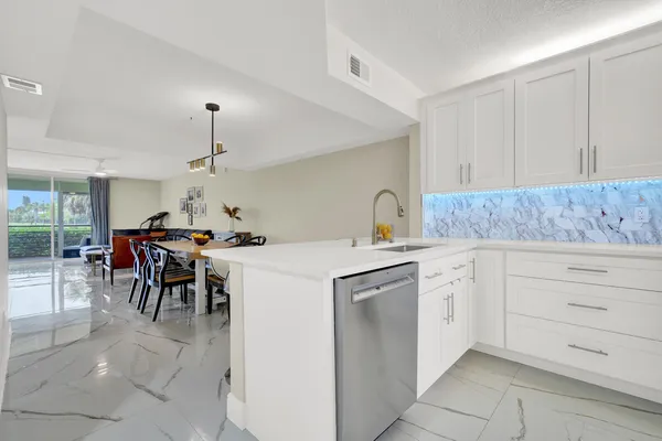 a kitchen with white cabinets and chairs