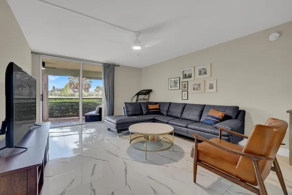 a living room with furniture a flat screen tv and a large window