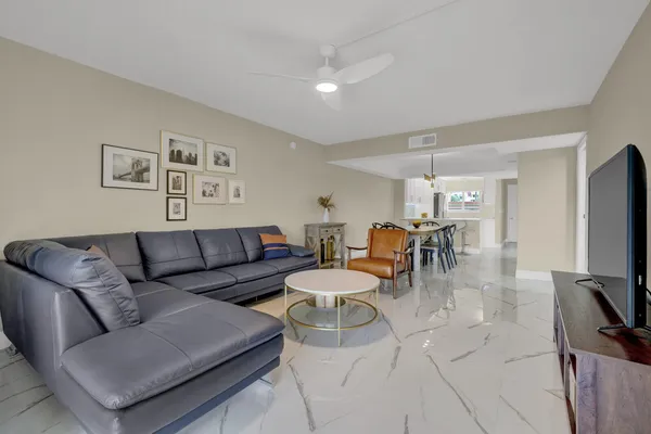 a living room with furniture a dining table and a flat screen tv