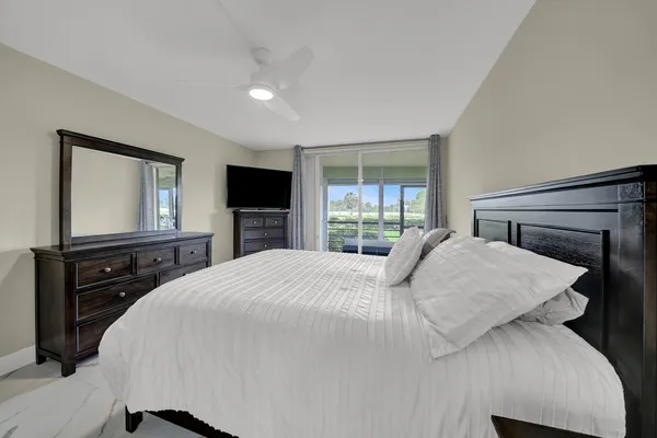 a bedroom with a large bed and a flat screen tv