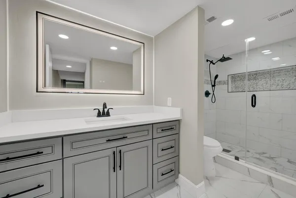a bathroom with a sink a toilet and shower