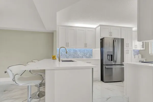 a kitchen with stainless steel appliances a refrigerator sink and cabinets