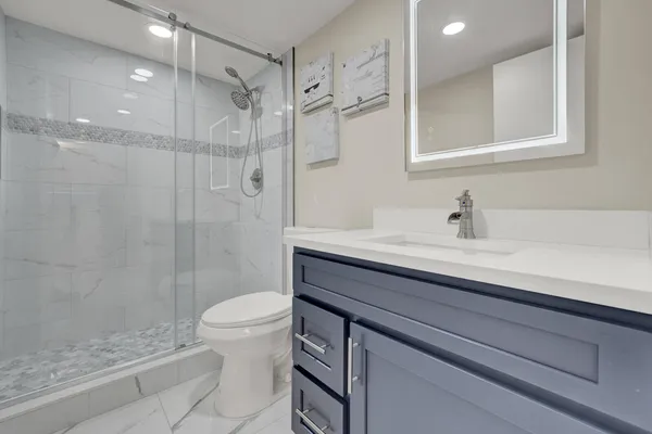 a bathroom with a sink a toilet and shower