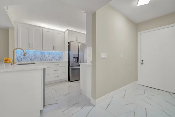 a kitchen with a refrigerator sink and cabinets