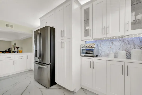 a kitchen with white cabinets and stainless steel appliances