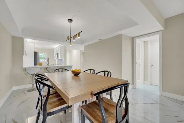 a view of a dining room with furniture and a chandelier fan