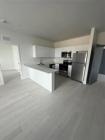 a kitchen with stainless steel appliances a refrigerator and a stove