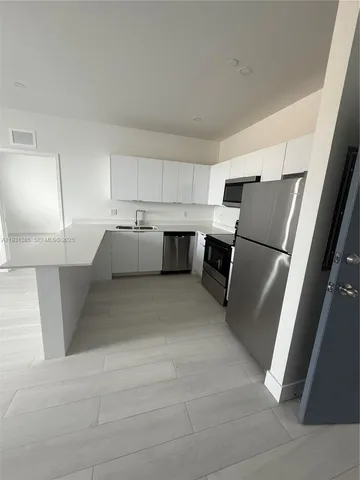 a kitchen with a refrigerator and a sink