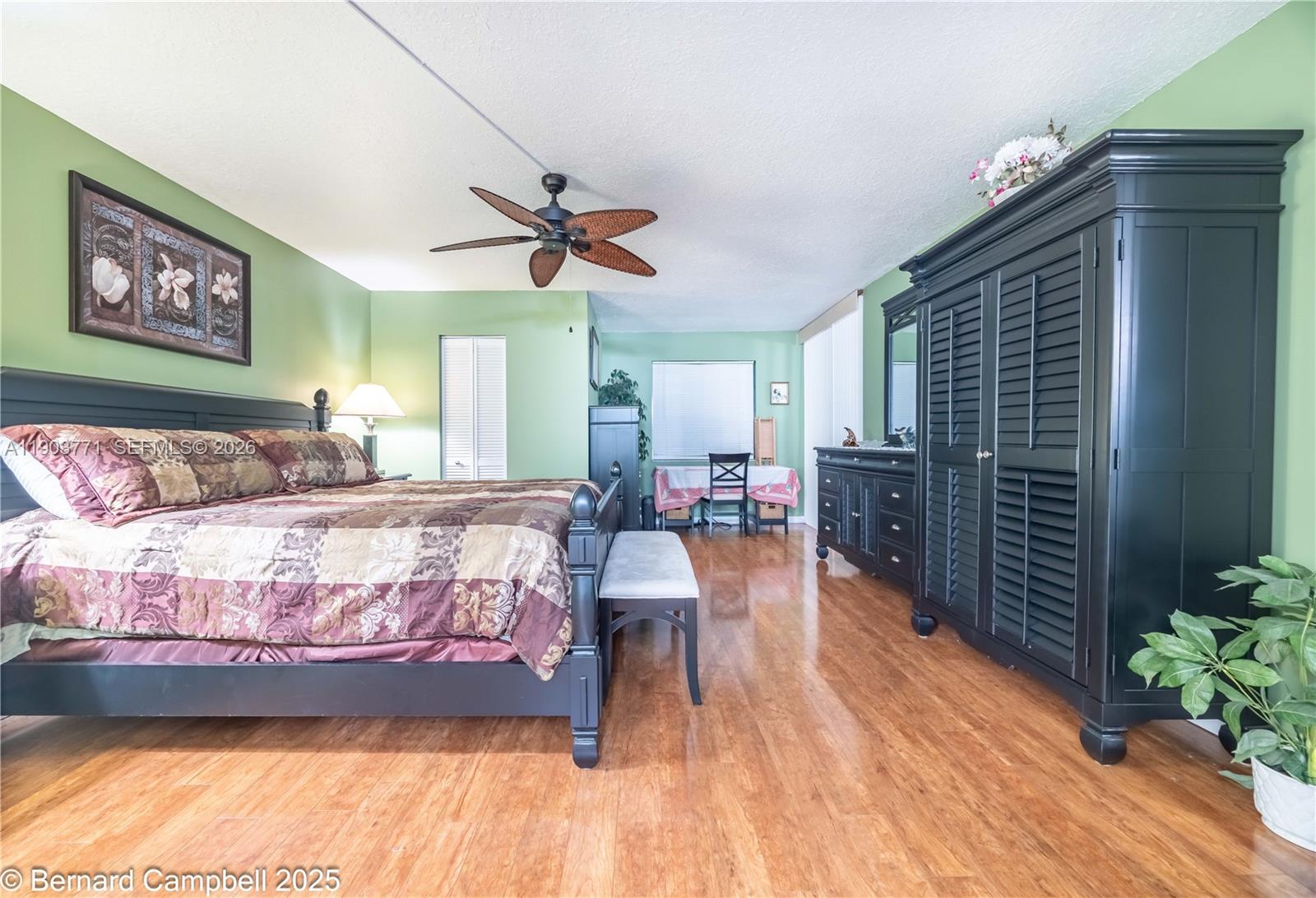 3910 Inverrary Boulevard, Unit 406B Lauderhill, FL 33319 - Photo 17 of 22 a bedroom with a bed dresser and a potted plant