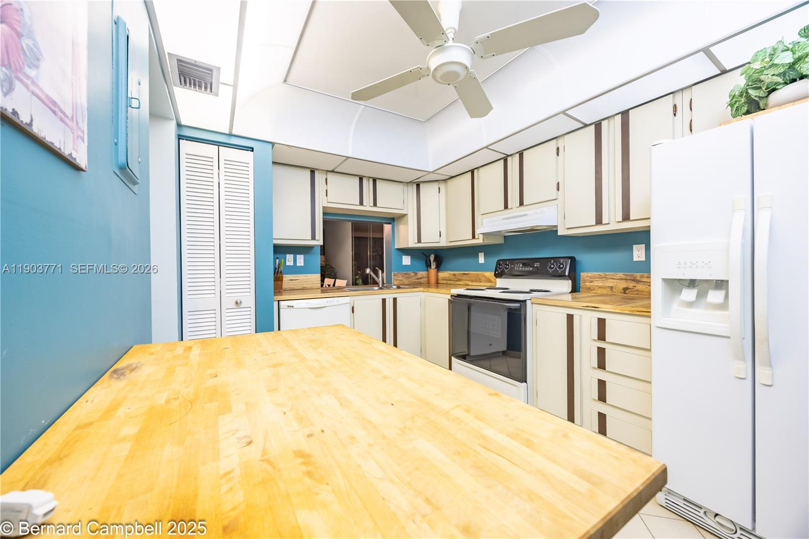 3910 Inverrary Boulevard, Unit 406B Lauderhill, FL 33319 - Photo 2 of 22 a kitchen with stainless steel appliances kitchen island granite countertop a refrigerator a stove sink and white cabinets with wooden floor