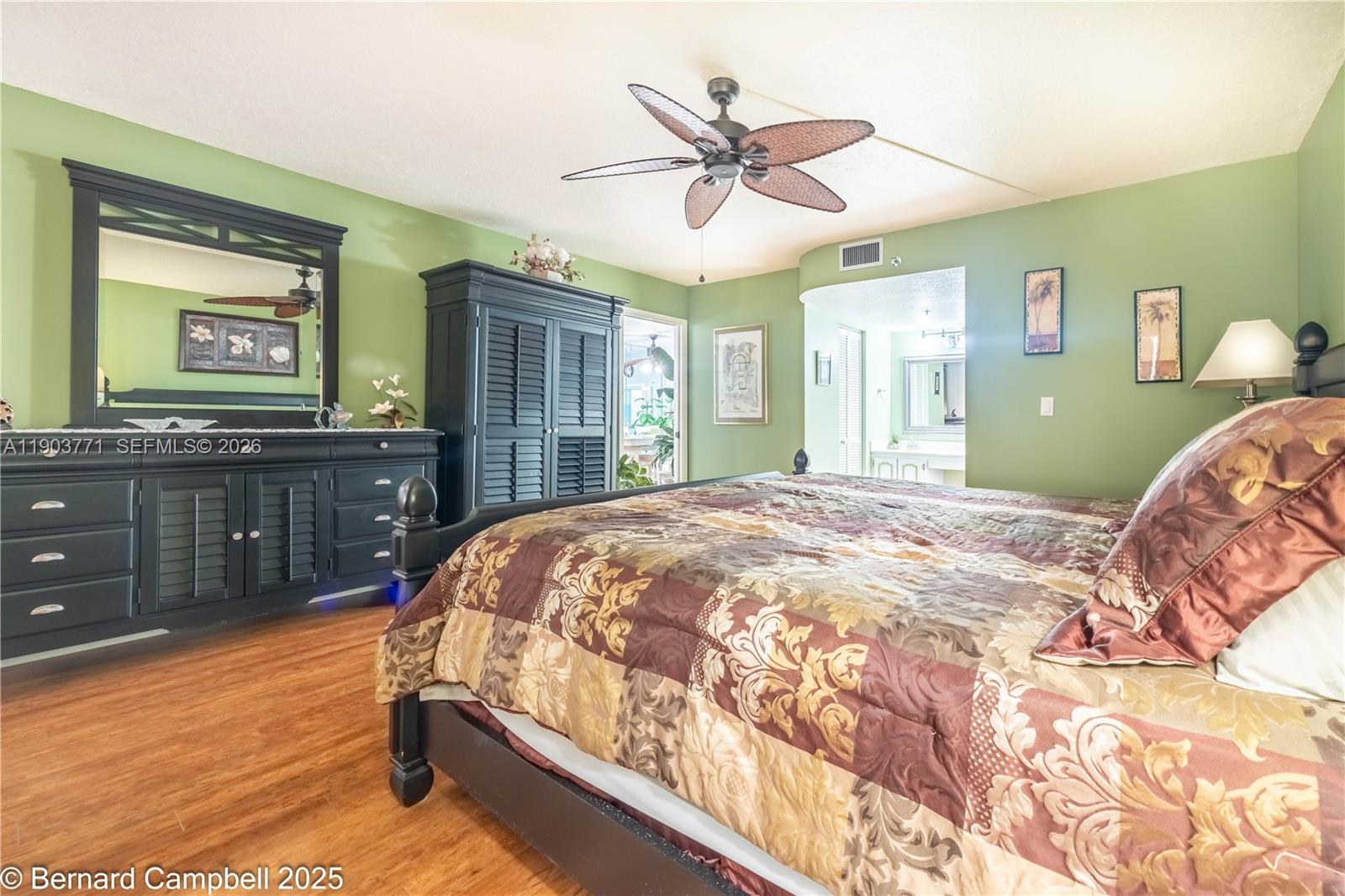 3910 Inverrary Boulevard, Unit 406B Lauderhill, FL 33319 - Photo 21 of 22 a bedroom with a bed and dresser with mirror