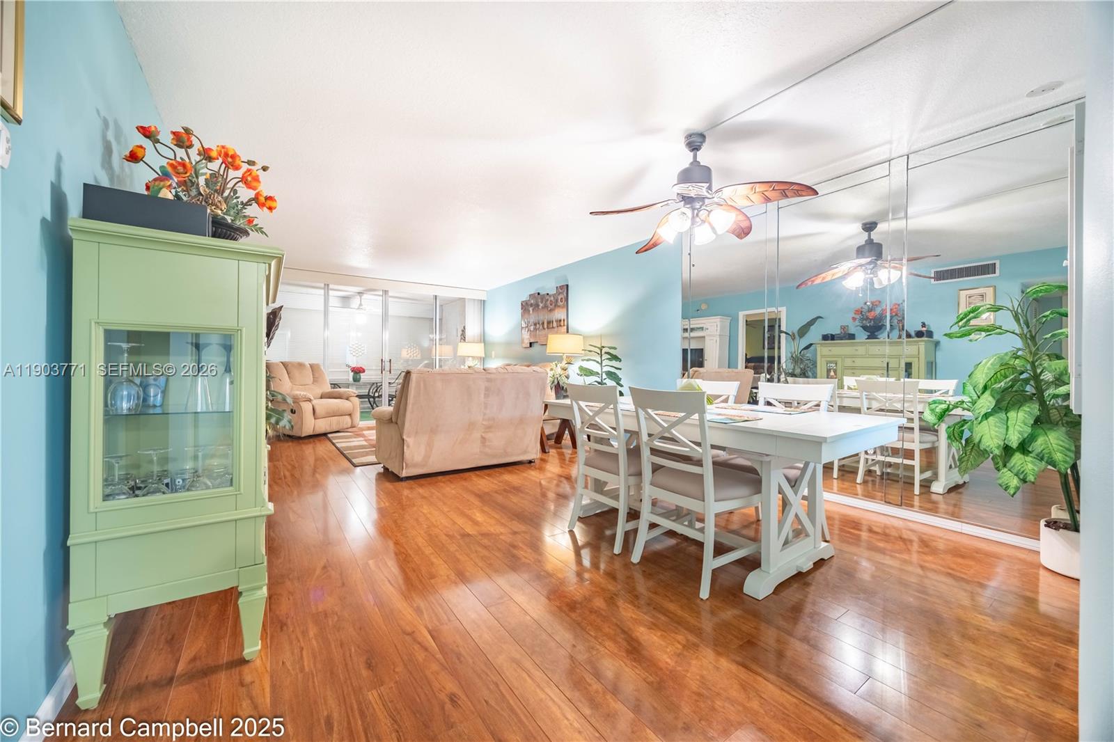 3910 Inverrary Boulevard, Unit 406B Lauderhill, FL 33319 - Photo 10 of 22 a dining room with wooden floor a chandelier a wooden table and chairs