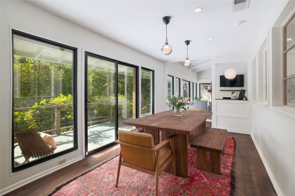 a view of a dining room with furniture large windows and wooden floor