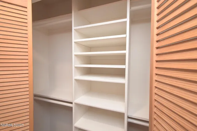 a view of walk in closet with empty racks