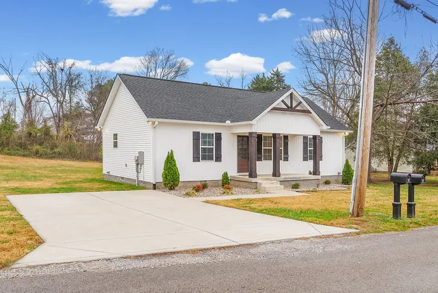 a view of a house with backyard and a tree
