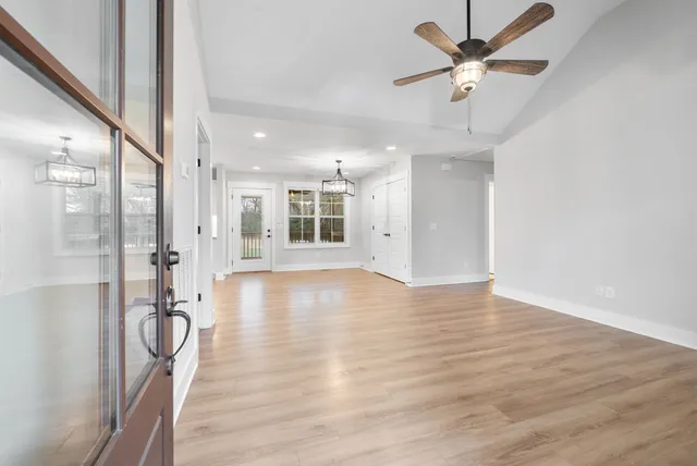 a view of a room with wooden floor and a ceiling fan