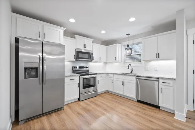 a kitchen with a refrigerator stove top oven and sink