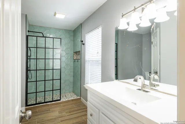 a bathroom with a sink a mirror and shower