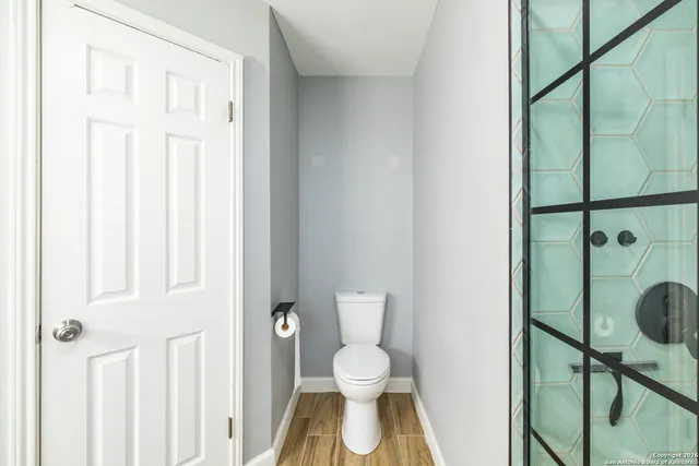 a bathroom with a toilet and a shower