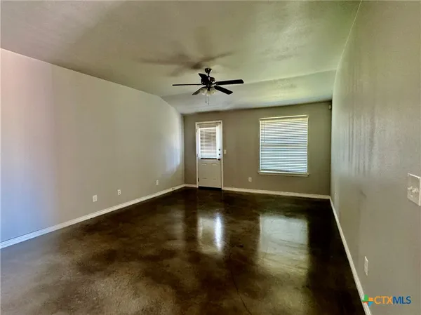 an empty room with a window and wooden floor