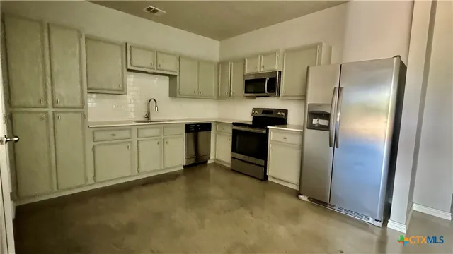 a kitchen with stainless steel appliances granite countertop a refrigerator and a sink