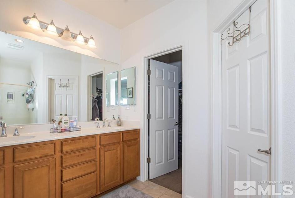 6923 Sacred Circle Sparks, NV 89436 - Photo 16 of 16 a bathroom with a double vanity sink a mirror and a shower
