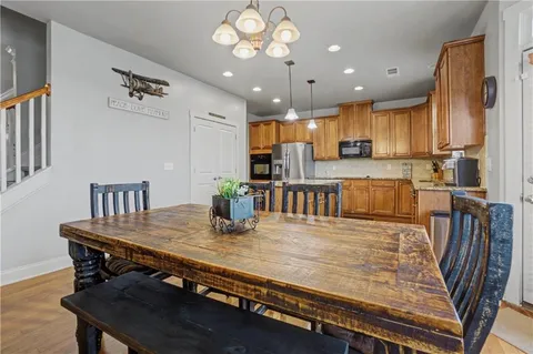 a kitchen with kitchen island stainless steel appliances a dining table and chairs