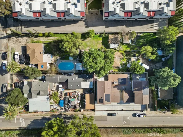an aerial view of residential houses with outdoor space and swimming pool