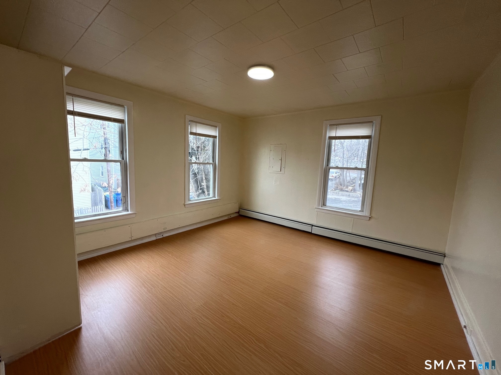 62 North Leonard Street Waterbury, CT 06708 - Photo 9 of 13 an empty room with wooden floor and windows