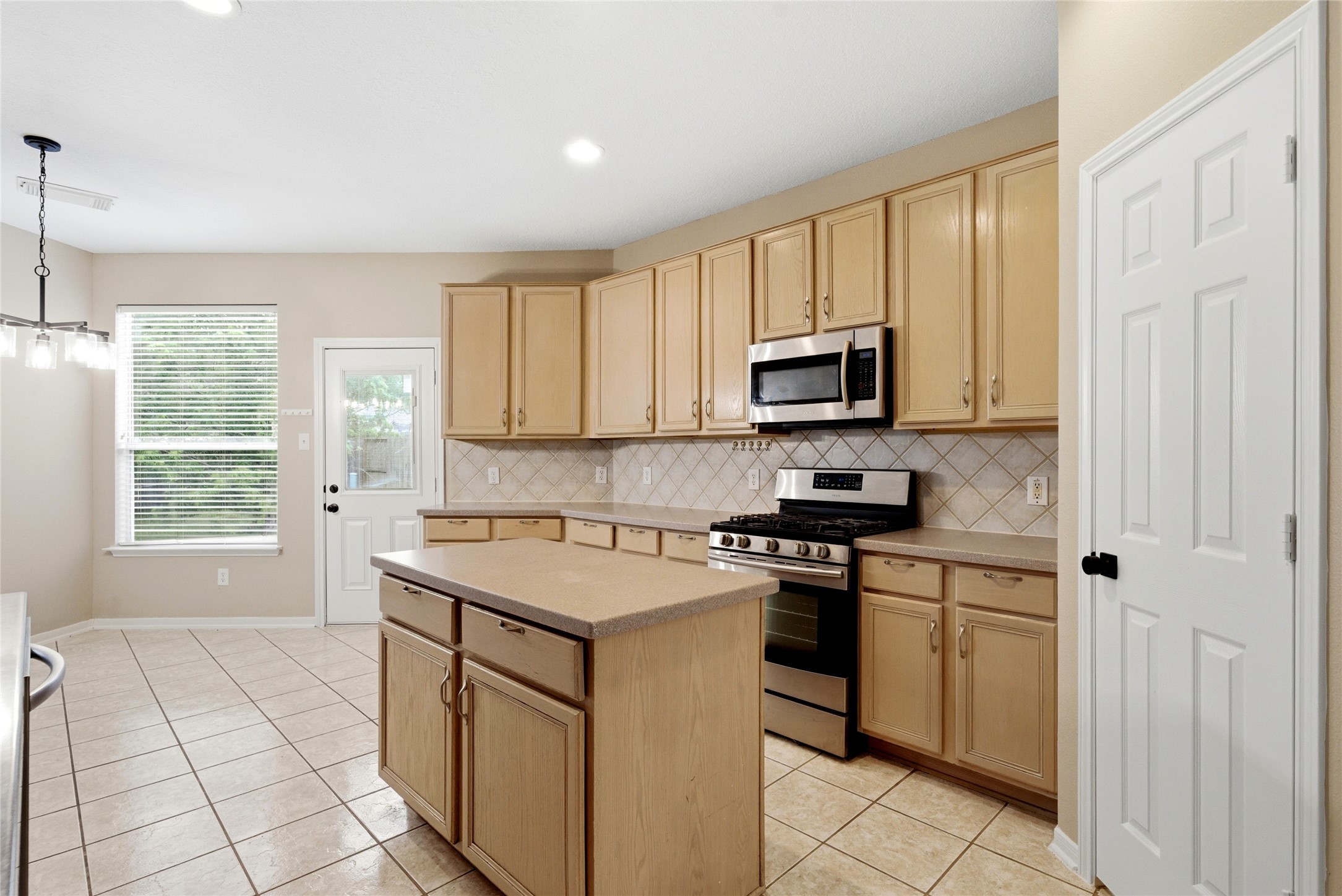 3711 Slocom Drive Katy, TX 77449 - Photo 14 of 46 a kitchen with a stove a sink and a microwave