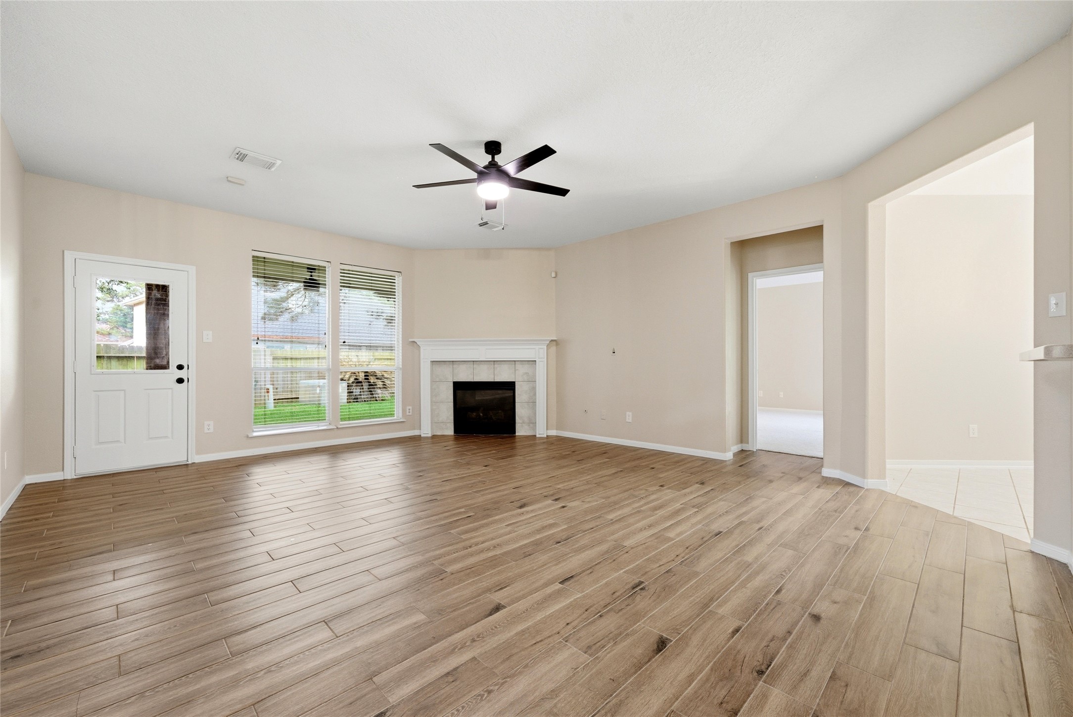 3711 Slocom Drive Katy, TX 77449 - Photo 19 of 46 an empty room with wooden floor fireplace and windows