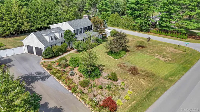 an aerial view of a house with a yard and lake view