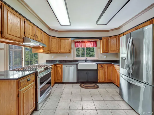a kitchen with stainless steel appliances granite countertop a sink and a refrigerator