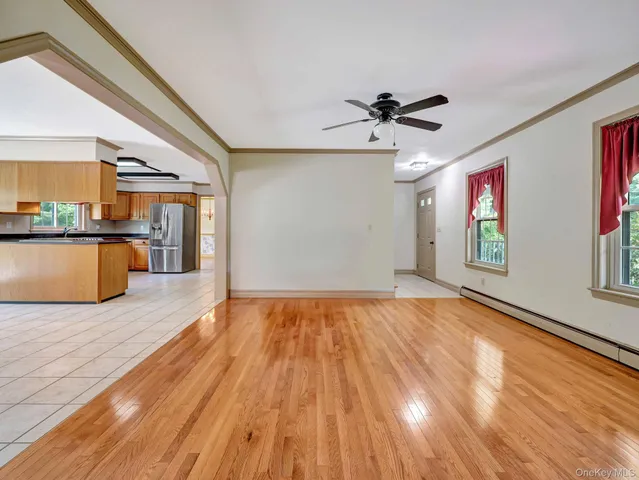 a view of a big room with wooden floor and windows