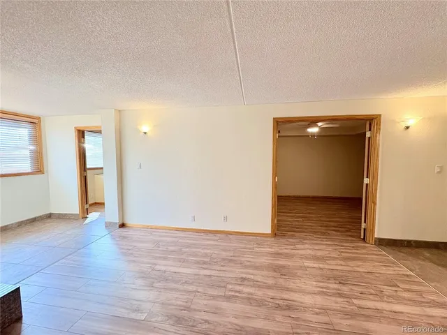 a view of an empty room with wooden floor and closet