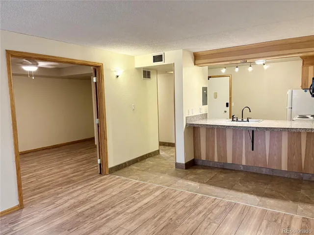 a view of a hallway with wooden floor and a sink
