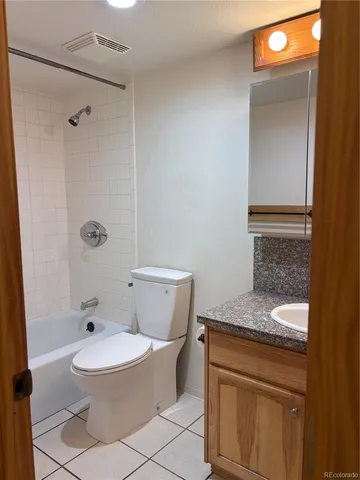 a bathroom with a granite countertop toilet a sink and a shower