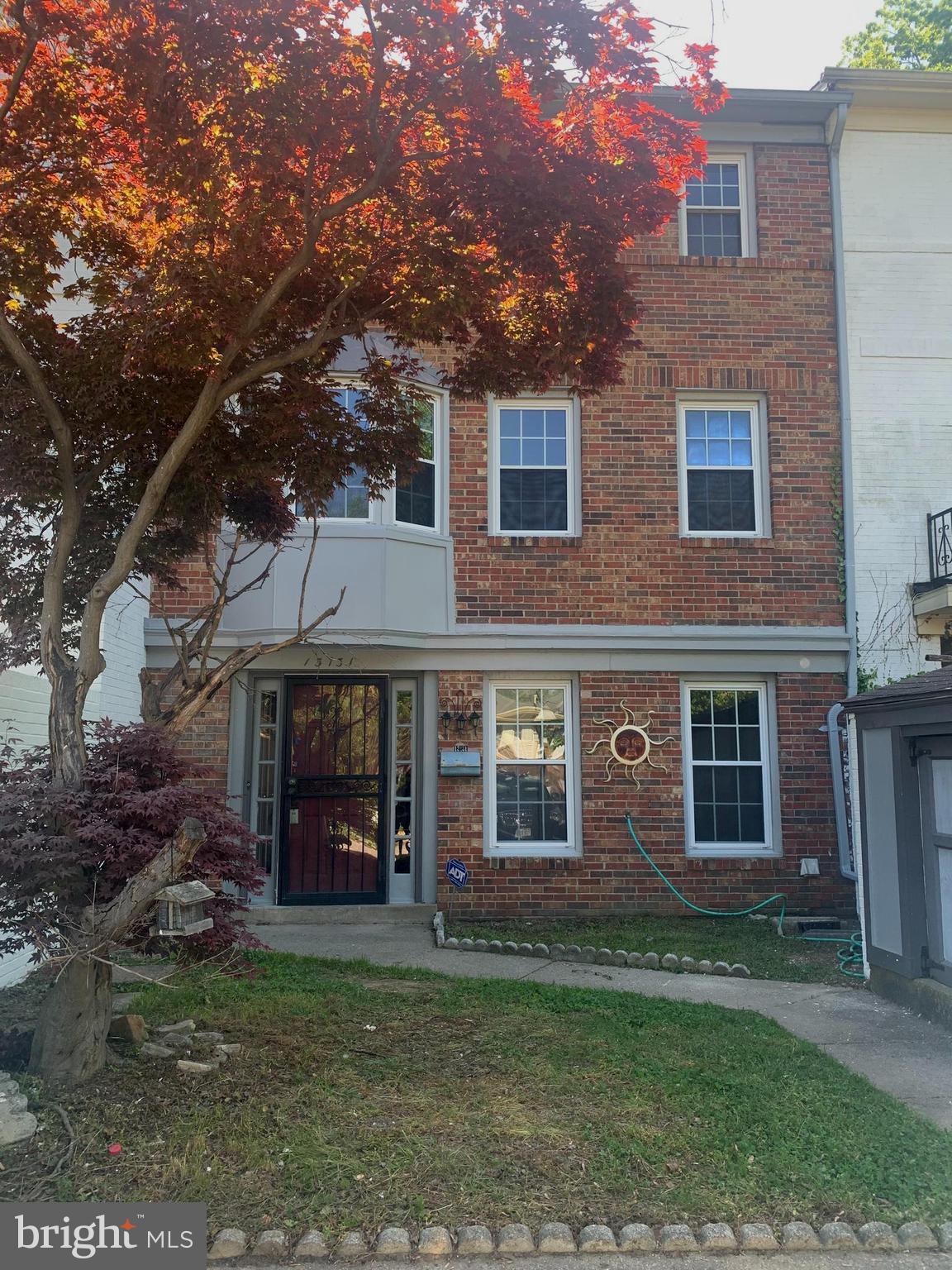 front view of a brick house with a yard