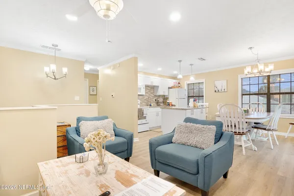 a living room with furniture and view of kitchen