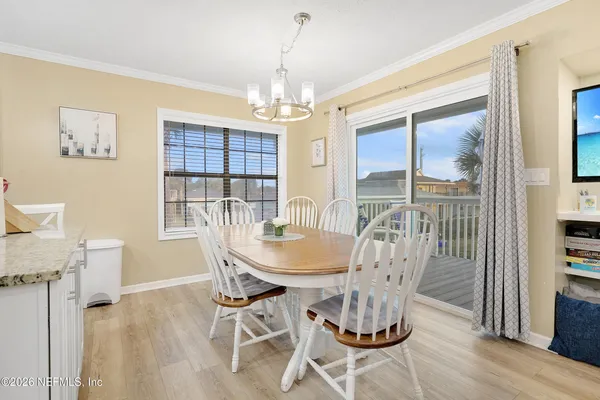 a dining room with furniture a chandelier and wooden floor