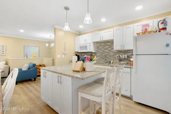 a kitchen with stainless steel appliances granite countertop a sink refrigerator and cabinets