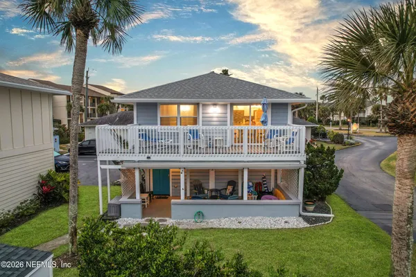 a front view of a house with garden and trees