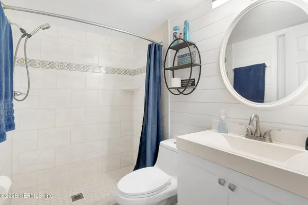 a bathroom with a sink vanity mirror and toilet