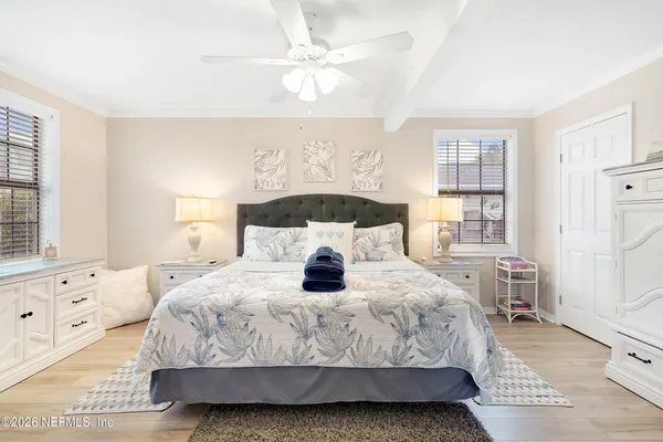 a bedroom with a large bed and a chandelier