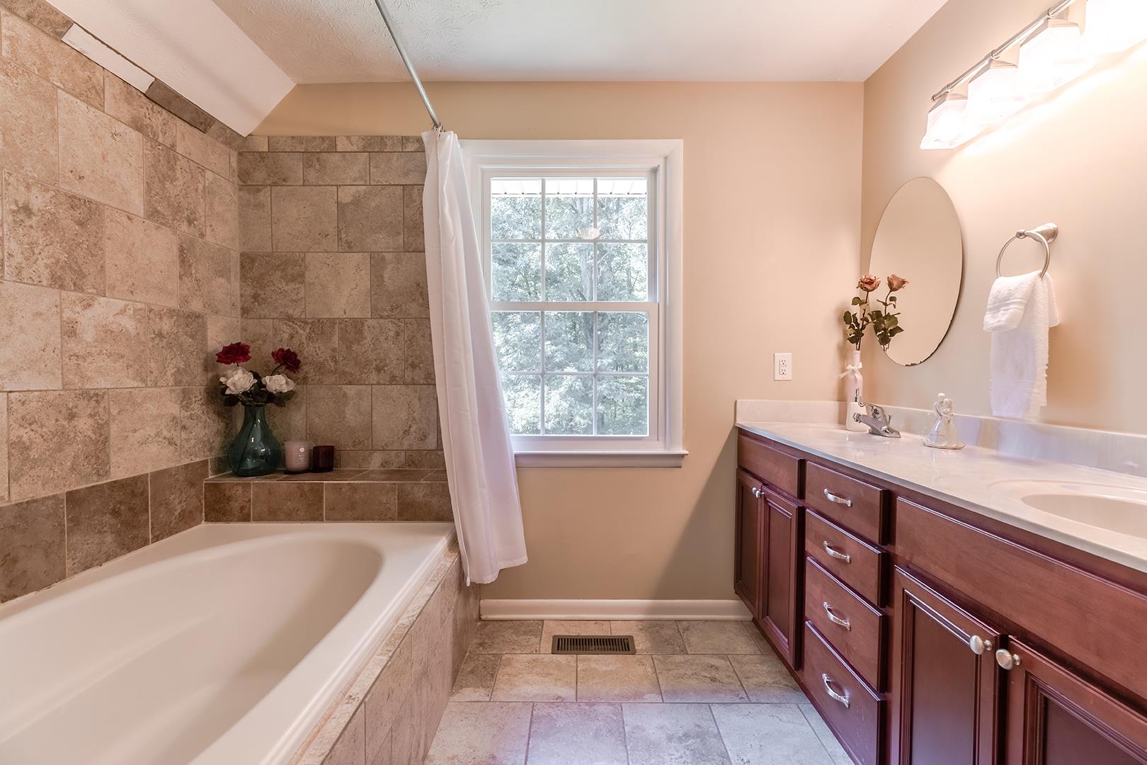 7574 King Road Fairview, TN 37062 - Photo 11 of 30 a bathroom with a tub sink and mirror