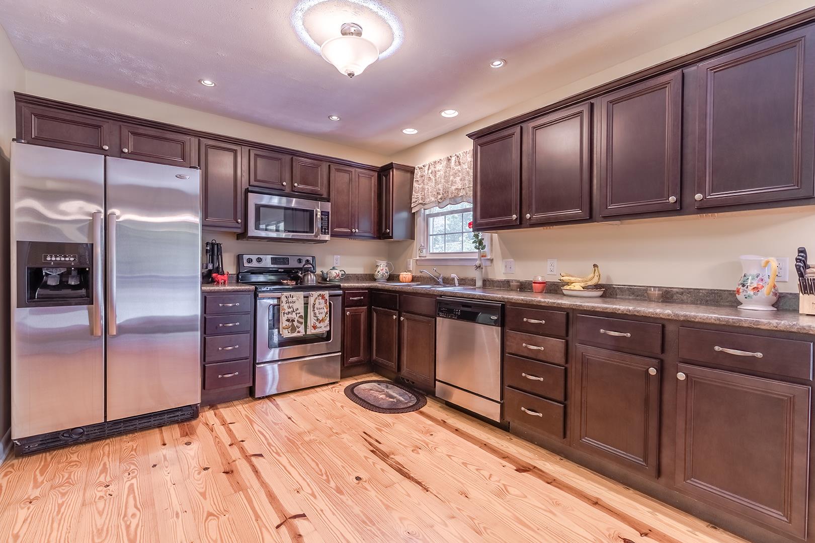 7574 King Road Fairview, TN 37062 - Photo 14 of 30 a kitchen with stainless steel appliances kitchen island granite countertop a refrigerator and a stove top oven