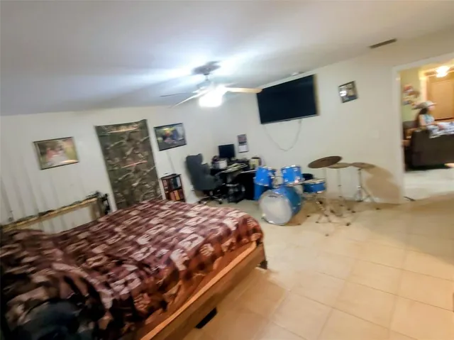 a bedroom with a bed a couch and a flat screen tv