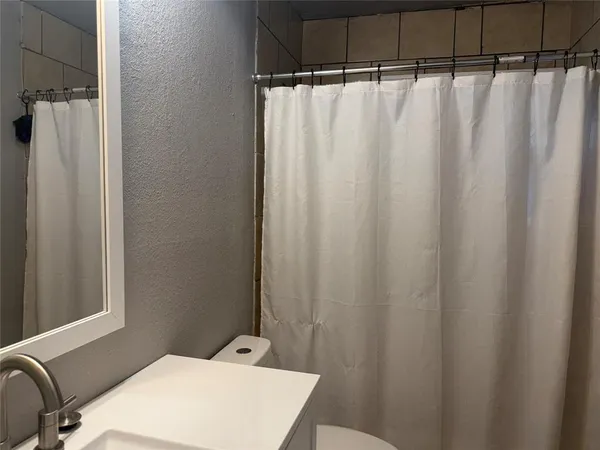 a bathroom with a shower curtain and sink