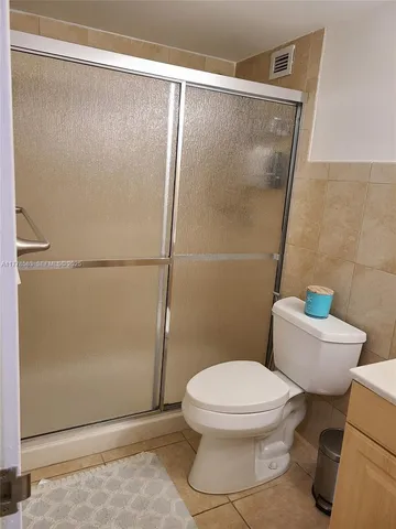 a white toilet sitting next to a shower